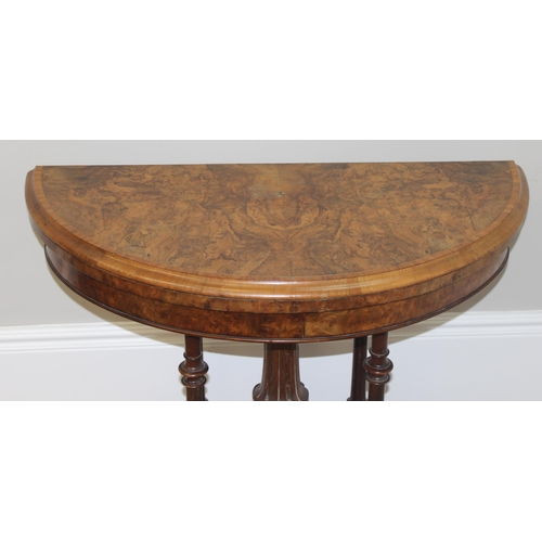 81 - A Victorian burr walnut card table with swivel, fold over top, and decorative carved base with 5 pil... 