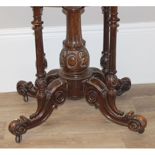 81 - A Victorian burr walnut card table with swivel, fold over top, and decorative carved base with 5 pil... 