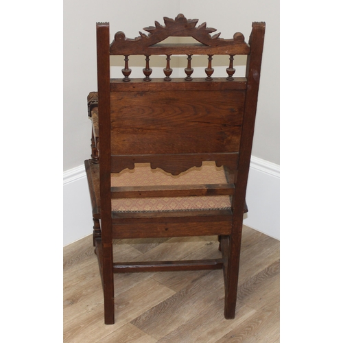 178 - Solid carved oak Wainscot style armchair with carved back panel depicting a male in profile, likely ... 