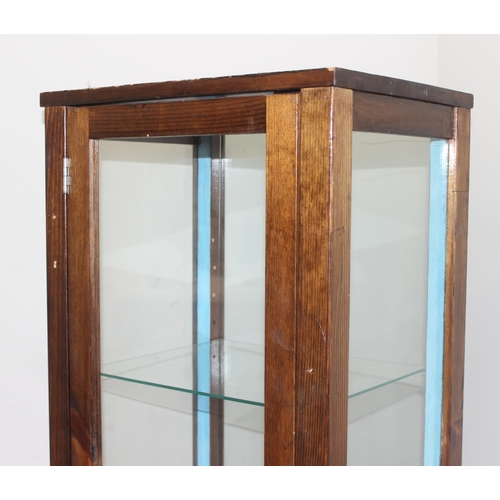 99 - Vintage stained pine and glass sided display cabinet with glass shelves and front castors, approx 44... 