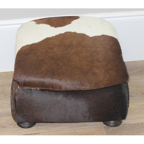 44 - A vintage style cowhide footstool, believed to be by Stone International, approx 54cm wide x 58cm de... 