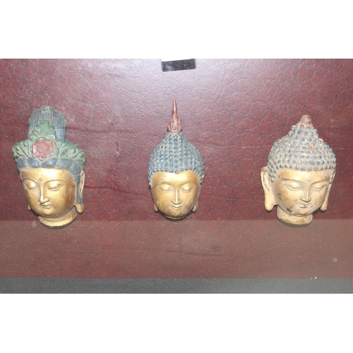 585 - A set of 3 buddha heads in boxed display frame, approx 80cm x 55cm