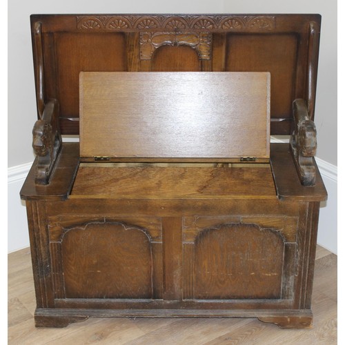 183 - A vintage antique style carved oak Monk's bench or storage box with lion supports, approx 96cm wide ... 