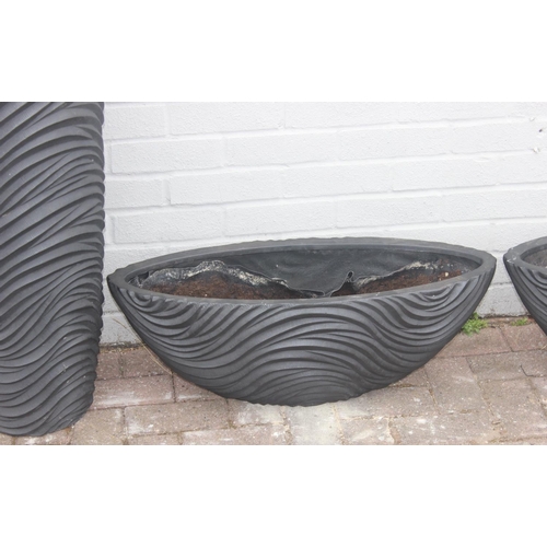 356 - A black fiberglass planter of spherical form with wavy textured design and a pair of smaller matchin... 