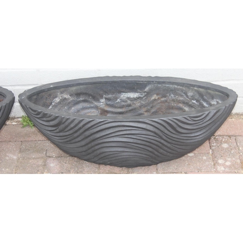 356 - A black fiberglass planter of spherical form with wavy textured design and a pair of smaller matchin... 