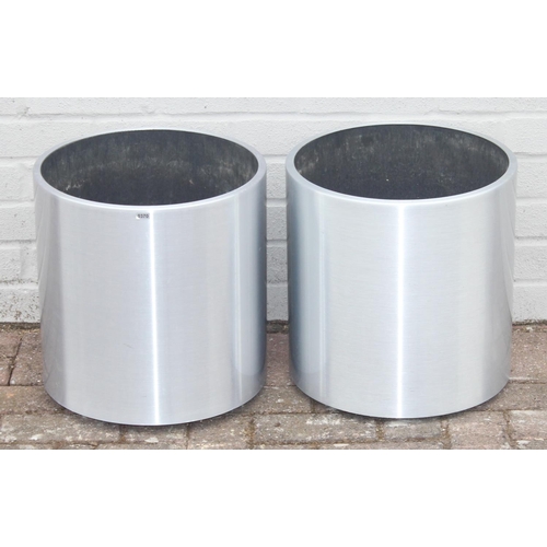 370 - A pair of brushed aluminium garden planters of cylindrical form, likely by Lune, on wheels with line... 