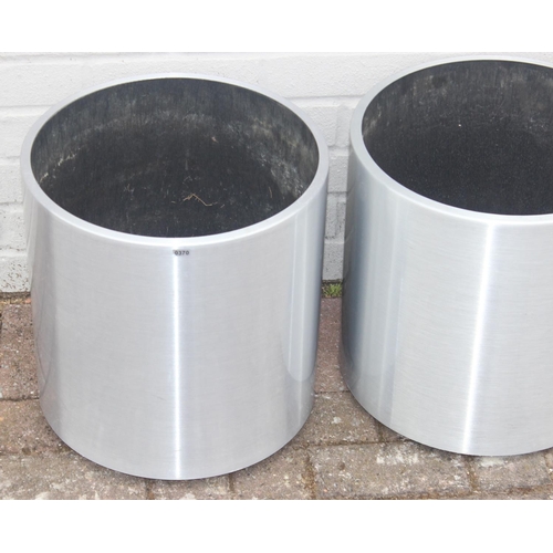 370 - A pair of brushed aluminium garden planters of cylindrical form, likely by Lune, on wheels with line... 