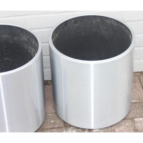 370 - A pair of brushed aluminium garden planters of cylindrical form, likely by Lune, on wheels with line... 