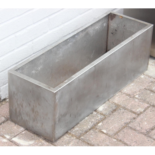 375 - 2 stainless steel trough shaped garden planters, the largest approx 67cm x 34cm x 38cm tall