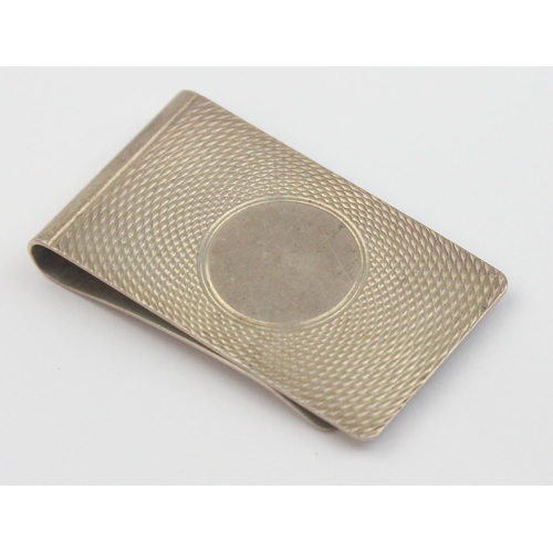 1011 - A vintage silver money clip with engine turned decoration, Birmingham 1985, approx 50mm wide, approx... 