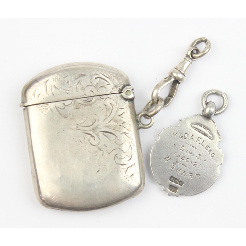 1018 - An antique silver vesta case with engraved decoration, Birmingham 1920, and a silver and enamel fob ... 