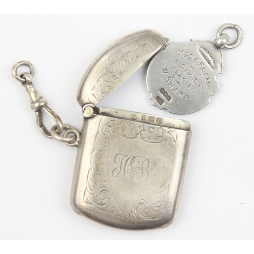 1018 - An antique silver vesta case with engraved decoration, Birmingham 1920, and a silver and enamel fob ... 