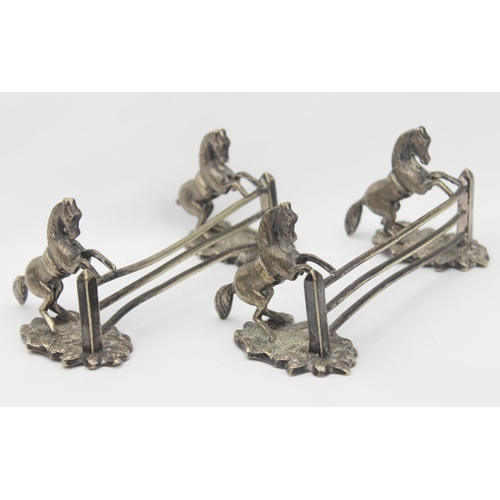 1029 - A pair of antique silver plated knife rests formed as a pair of horses jumping a 3 bar fence, each u... 