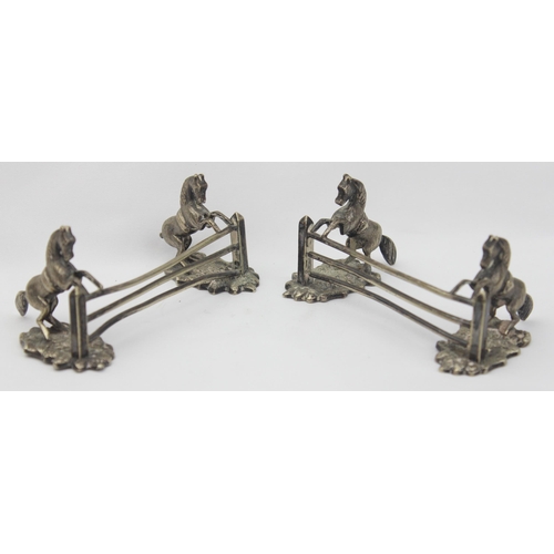 1029 - A pair of antique silver plated knife rests formed as a pair of horses jumping a 3 bar fence, each u... 