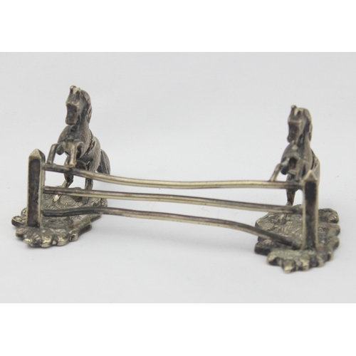 1029 - A pair of antique silver plated knife rests formed as a pair of horses jumping a 3 bar fence, each u... 