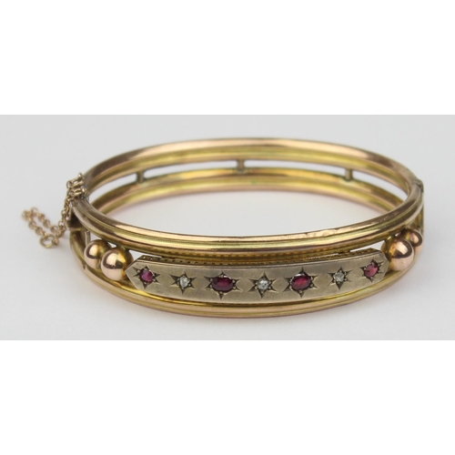 1100 - A Victorian 9ct gold cuff bangle set with rubies and diamonds, 4 rubies and 3 diamonds in star cut s... 