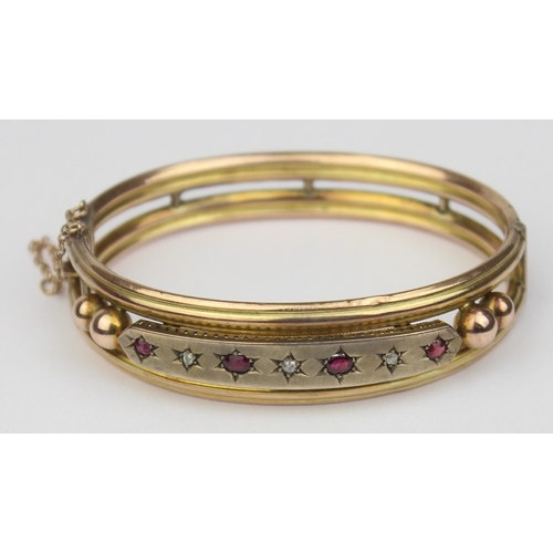 1100 - A Victorian 9ct gold cuff bangle set with rubies and diamonds, 4 rubies and 3 diamonds in star cut s... 