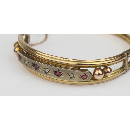 1100 - A Victorian 9ct gold cuff bangle set with rubies and diamonds, 4 rubies and 3 diamonds in star cut s... 