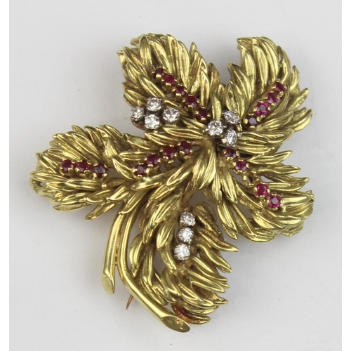 1104 - In the manner of Tiffany & Co, a retro 18ct gold ruby and diamond brooch formed as leaves or feather... 