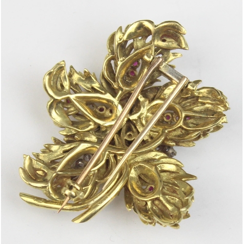 1104 - In the manner of Tiffany & Co, a retro 18ct gold ruby and diamond brooch formed as leaves or feather... 