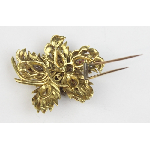 1104 - In the manner of Tiffany & Co, a retro 18ct gold ruby and diamond brooch formed as leaves or feather... 