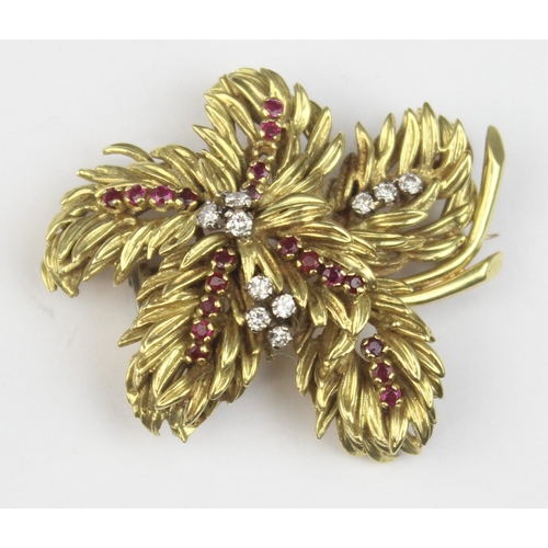 1104 - In the manner of Tiffany & Co, a retro 18ct gold ruby and diamond brooch formed as leaves or feather... 