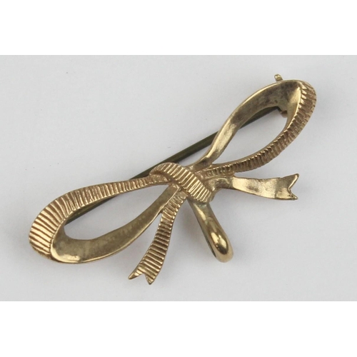 1108 - A 9ct gold brooch formed as a bow, marked and XRF confirmed, with base metal pin, approx 38mm wide, ... 