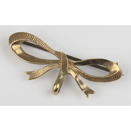 1108 - A 9ct gold brooch formed as a bow, marked and XRF confirmed, with base metal pin, approx 38mm wide, ... 