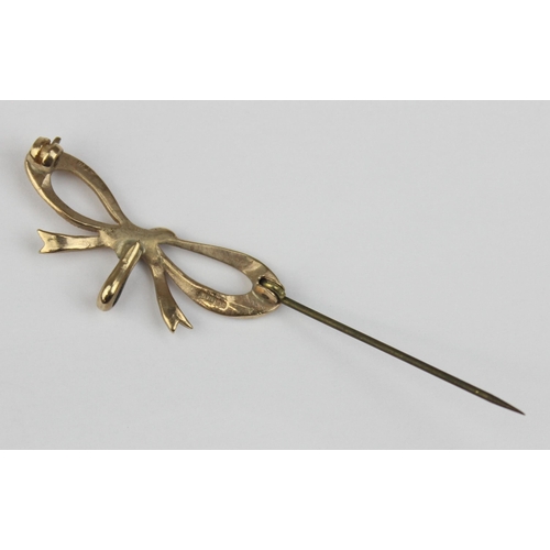 1108 - A 9ct gold brooch formed as a bow, marked and XRF confirmed, with base metal pin, approx 38mm wide, ... 