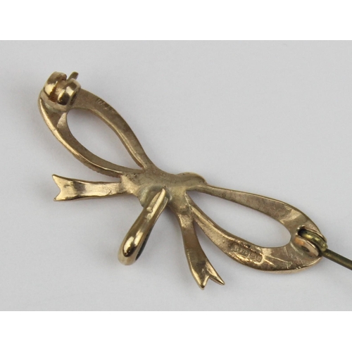 1108 - A 9ct gold brooch formed as a bow, marked and XRF confirmed, with base metal pin, approx 38mm wide, ... 