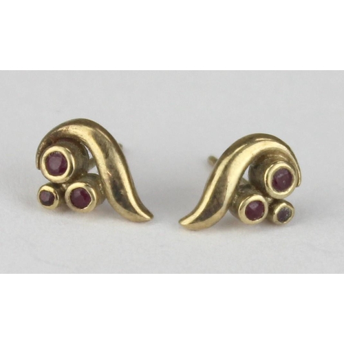 1112 - A pair of retro style 9ct gold and ruby earring, each stud set with 3 small rubies in a flame style ... 