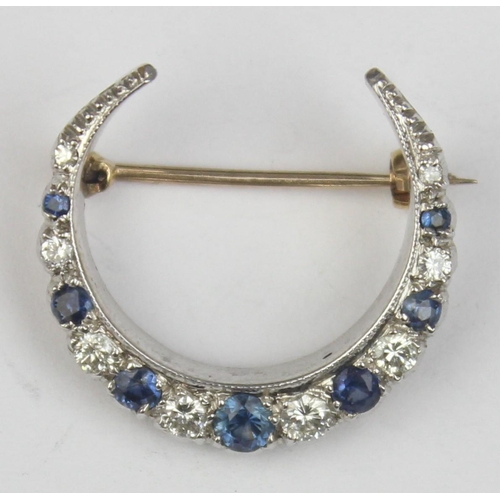 1140 - A 9ct gold crescent brooch set with blue and white stones, believed to be diamonds and sapphires, se... 