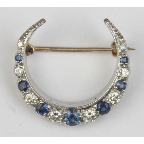 1140 - A 9ct gold crescent brooch set with blue and white stones, believed to be diamonds and sapphires, se... 