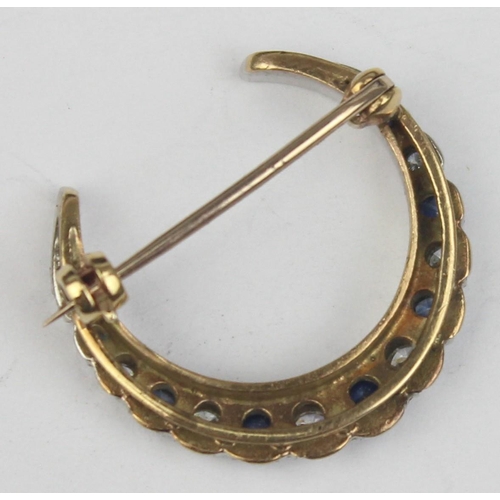 1140 - A 9ct gold crescent brooch set with blue and white stones, believed to be diamonds and sapphires, se... 