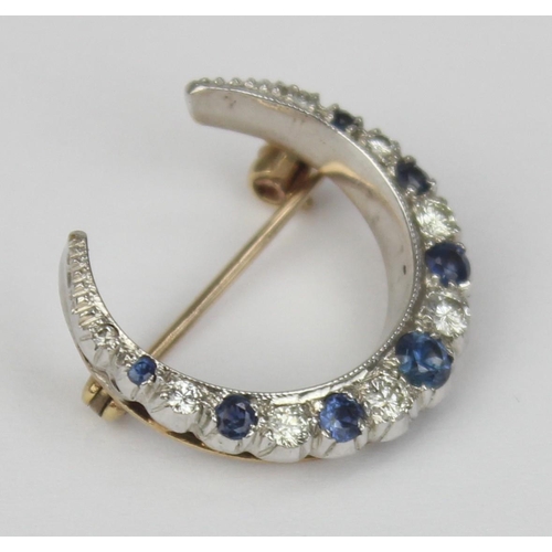 1140 - A 9ct gold crescent brooch set with blue and white stones, believed to be diamonds and sapphires, se... 