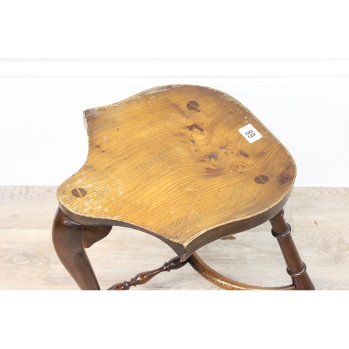 89 - A vintage Stewart Linford style elm seated saddle seated stool, unsigned, approx 39cm wide x 35cm de... 