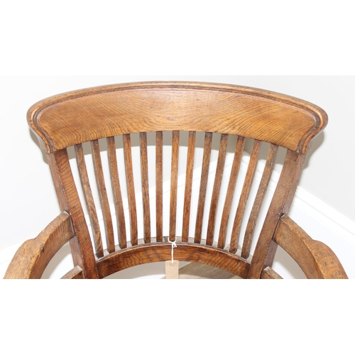 10 - An early 20th century oak armchair or desk chair on brass castors, approx 60cm wide x 55cm deep x 91... 