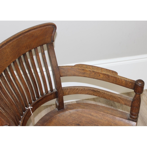 10 - An early 20th century oak armchair or desk chair on brass castors, approx 60cm wide x 55cm deep x 91... 