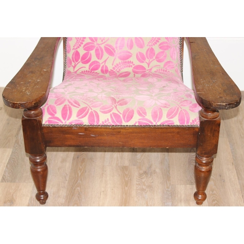 23 - An antique plantation chair with turned legs and later retro style pink floral upholstery, approx 10... 