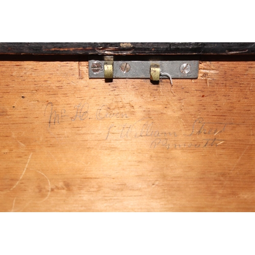 51 - A large antique black painted pine trunk, likely a naval tool box with rope handles, named to interi... 