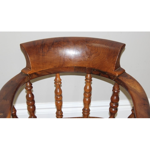 172 - An antique smokers bow or captain's chair, believed to be an elm seat and yew wood arms, with turned... 