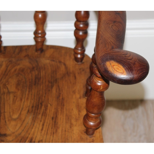 172 - An antique smokers bow or captain's chair, believed to be an elm seat and yew wood arms, with turned... 