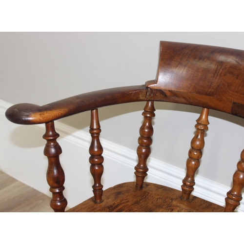 172 - An antique smokers bow or captain's chair, believed to be an elm seat and yew wood arms, with turned... 