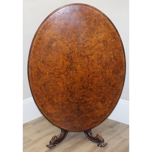 170 - A 19th century burr walnut tilt top oval breakfast table, the heavily carved base with 4 legs and ce... 