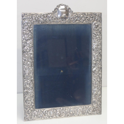 1001 - A large Sterling silver photograph frame decorated with embossed flowers and acanthus scrolls, Spani... 