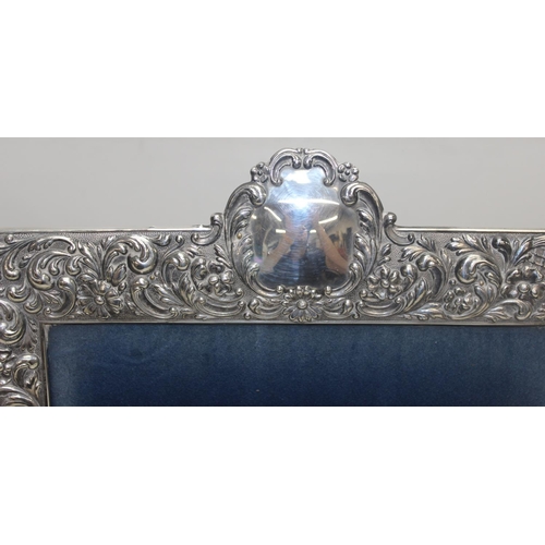 1001 - A large Sterling silver photograph frame decorated with embossed flowers and acanthus scrolls, Spani... 