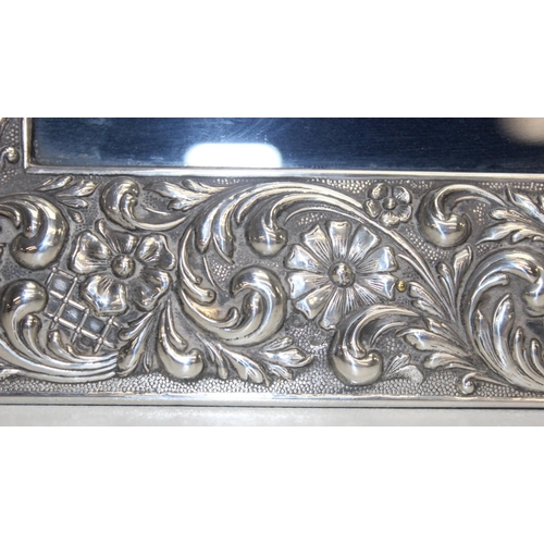 1001 - A large Sterling silver photograph frame decorated with embossed flowers and acanthus scrolls, Spani... 