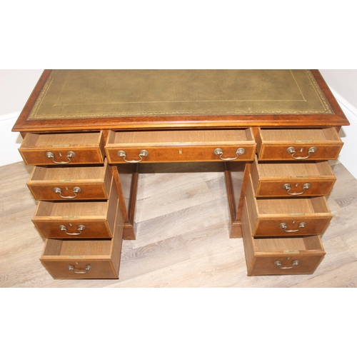 11 - A quality antique style pedestal desk with green inset gilt tooled leather top, walnut or yew wood w... 