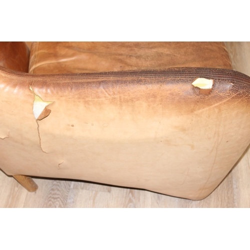 13 - A pair of Balzac club or armchairs in tan leather and a matching footstool, designed by Matthew Hilt... 