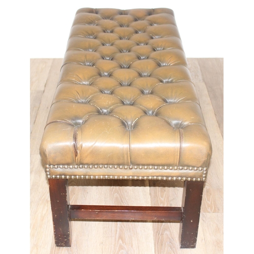 26 - A Victorian Revival Chesterfield style ottoman or footrest of rectangular form upholstered in tan bu... 